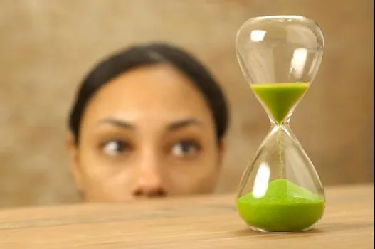 woman looking at hourglass